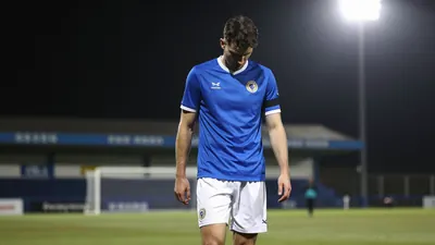 A tight waist-up shot of an anonymous Eastleigh player in a blue jersey and white shorts, looking dejected as he walks...