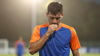 A determined, sweat-drenched Eastleigh midfielder, 25, with a strong build, wearing a plain blue and orange training top...